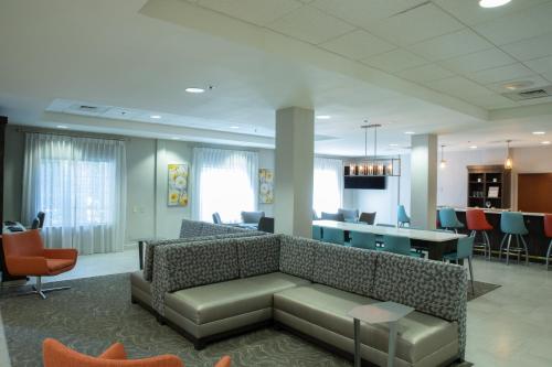 a lobby with a couch and a table and chairs at Holiday Inn & Suites Raleigh Cary by IHG in Cary