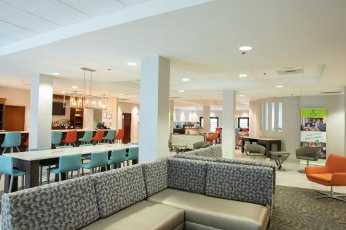 a lobby of a hospital with a couch and chairs at Holiday Inn & Suites Raleigh Cary by IHG in Cary