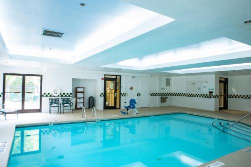 a large swimming pool with blue water in a room at Holiday Inn & Suites Raleigh Cary by IHG in Cary