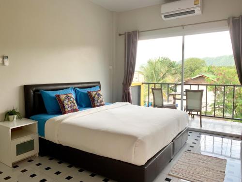 a bedroom with a large bed and a balcony at Lom La Lanta in Ko Lanta