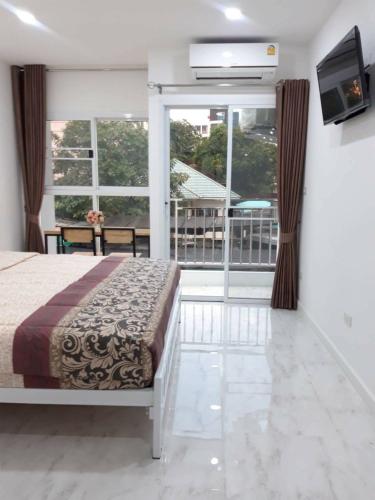 a bedroom with a bed and a large window at Parvena Ratchada in Bangkok
