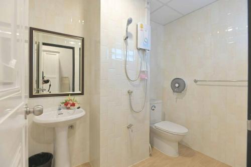 a bathroom with a shower and a toilet and a sink at Parvena Ratchada in Bangkok