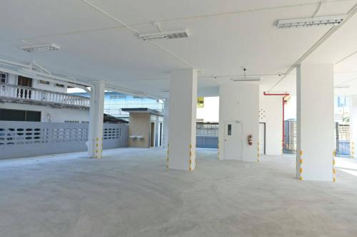 an empty room with white columns in a building at Parvena Ratchada in Bangkok