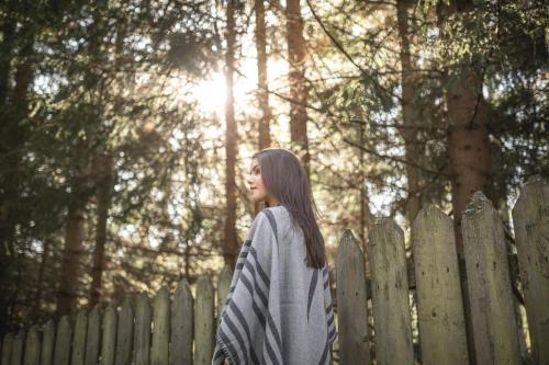 a young woman standing next to a fence at Hotel Tann in Collalbo