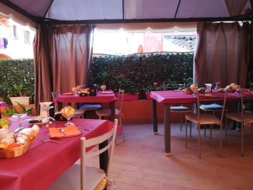 a group of tables with pink table cloths in a tent at Affittacamere Le Statue Del Sinis in Càbras