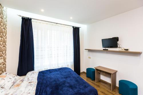 um quarto com uma cama azul e uma janela em 2 Kn. Romana Apartment em Lviv