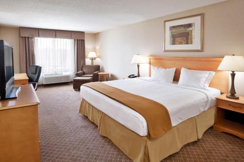 a hotel room with a large bed and a television at Holiday Inn Express Hotel & Suites Chesterfield - Selfridge Area by IHG in Chesterfield