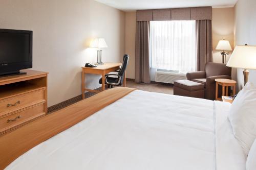 a hotel room with a bed and a desk and a television at Holiday Inn Express Hotel & Suites Chesterfield - Selfridge Area by IHG in Chesterfield