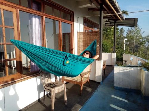 a woman laying in a hammock on a house at Il Villino haputale in Haputale