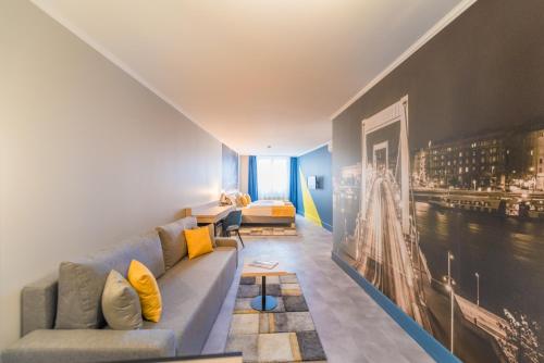 a living room with a couch and a painting on the wall at Impulso Fashion Hotel in Budapest
