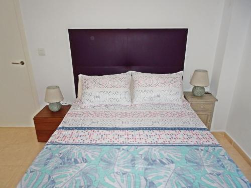 una camera con un letto con due lampade sui comodini di ALMIRANTE Vista al mar - Alquiler familias a Playa de Gandia