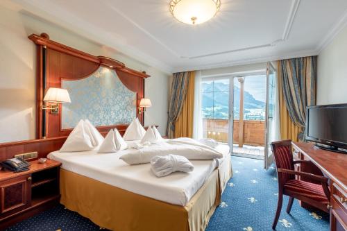 una camera d'albergo con un grande letto e una TV di Hotel Seehof a Walchsee
