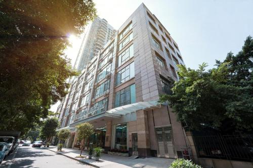 a tall building on a city street with tall buildings at Magnotel Renmin Road City Hall QingYuan in Qingyuan