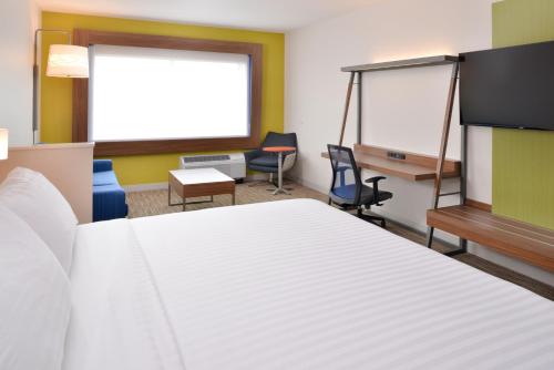 a room with a bed and desks and chairs at Holiday Inn Express & Suites Madison by IHG in Madison