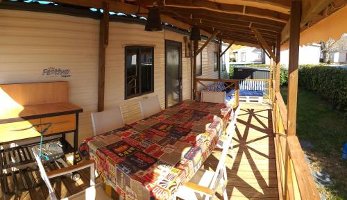 une terrasse couverte d'une maison avec une table et des chaises dans l'établissement SIBLU CONDRIEU, à Condrieu