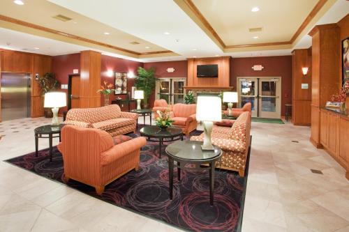 a lobby with orange chairs and tables in a hotel at Holiday Inn Hotel & Suites Grand Junction-Airport by IHG in Grand Junction