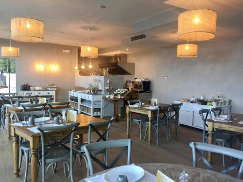 un restaurant avec des tables et des chaises et une cuisine dans l'établissement BnB Borgo le Vigne - La Vendemmia, à Tignale