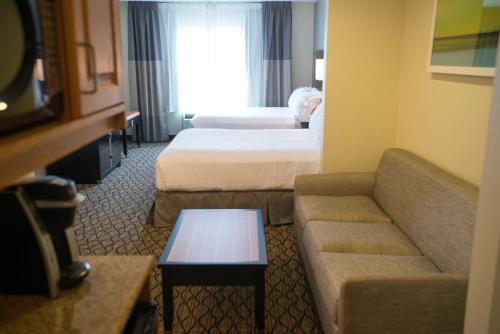 a hotel room with two beds and a couch at Holiday Inn Express Hotel & Suites Chanhassen by IHG in Chanhassen
