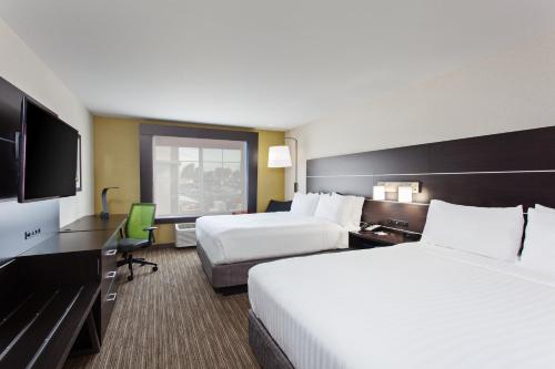 a hotel room with two beds and a flat screen tv at Holiday Inn Express & Suites Oakland - Airport, an IHG Hotel in Oakland