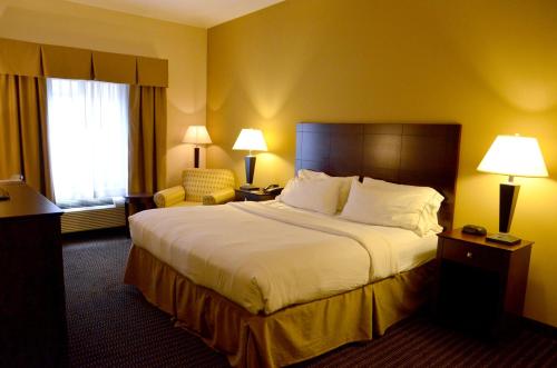 een hotelkamer met een groot bed en een stoel bij Holiday Inn Express & Suites Sidney, an IHG Hotel in Sidney