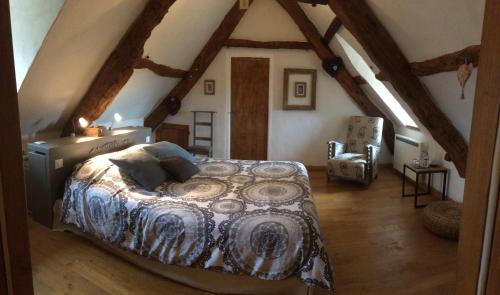 une chambre avec un lit dans un grenier dans l'établissement Le Couvent, à Saint-Jean-de Laurs