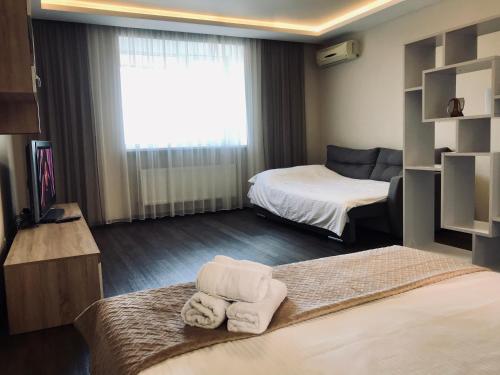 een hotelkamer met 2 bedden en 2 handdoeken bij Просторная однокомнатная ЖК Счастливый in Dnipro