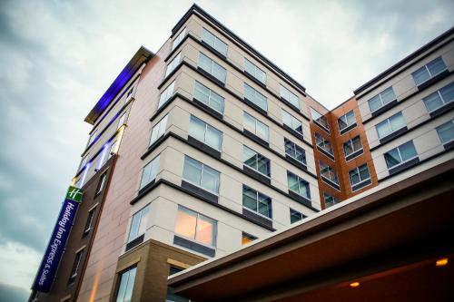 a tall building with a sign on the side of it at Holiday Inn Express & Suites Downtown Louisville by IHG in Louisville