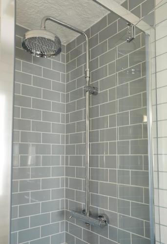 a bathroom with a shower with blue tiles at Darrington by Greene King Inns in Darrington