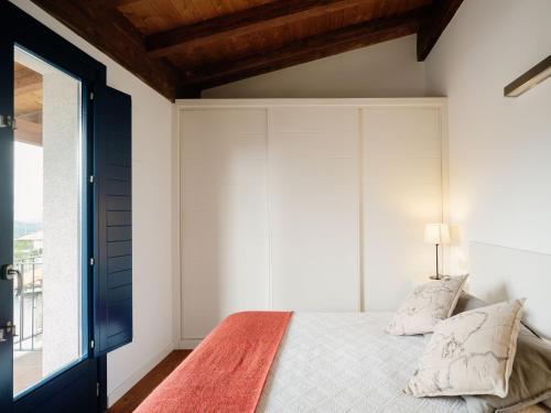 a bedroom with a bed with white walls and a window at Apartamentos Ribeira Sacra in Parada del Sil