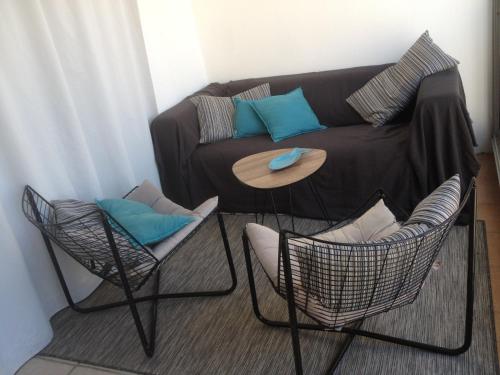 uma sala de estar com um sofá e duas cadeiras em Appartement vue mer em Six-Fours-les-Plages