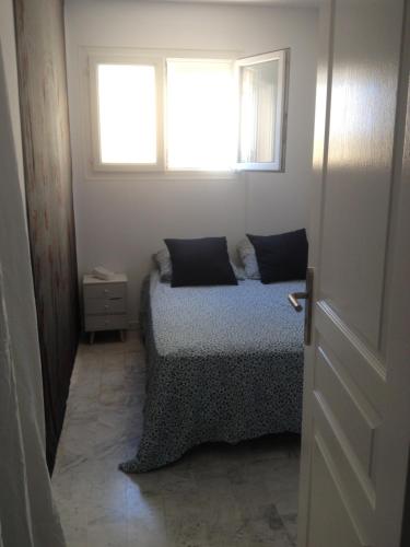 シス・フール・レ・プラージュにあるAppartement vue merの小さなベッドルーム(ベッド1台、窓付)