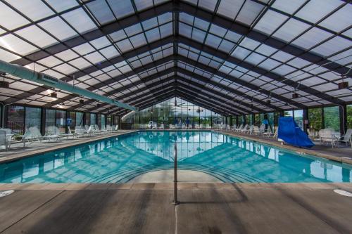 een groot zwembad met een glazen plafond bij Holiday Inn Club Vacations Holiday Hills Resort at Branson an IHG Hotel in Branson
