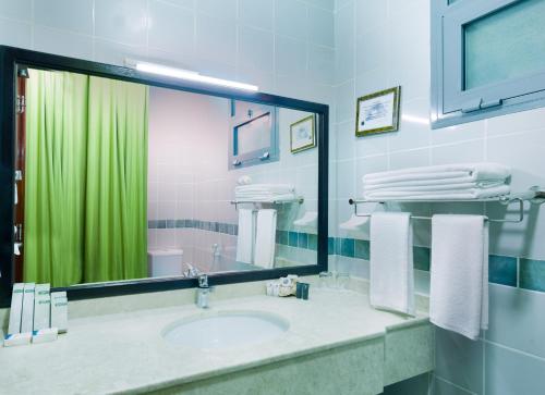 a bathroom with a sink and a green shower curtain at Ras Al Jinz Turtle Reserve in Sur