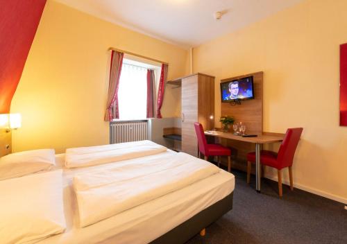 a hotel room with a bed and a table at Hotel Cafe Lieb in Bamberg