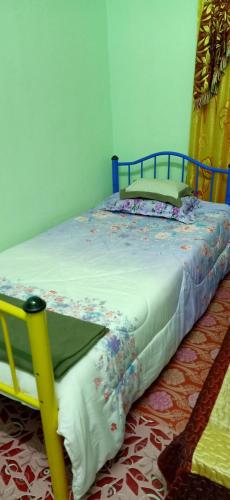 a bedroom with a bed with a blue frame at Homestay Damai Sri Kota in Kepala Batas