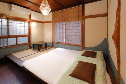 横浜市にあるゲストハウス FUTARENOのベッドとテーブル付きの小さな部屋
