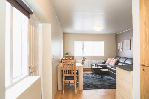 a kitchen and living room with a table and a couch at E18 Apartments in Akureyri