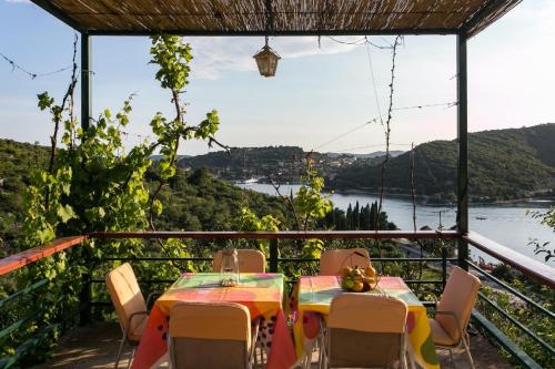 een tafel en stoelen op een balkon met uitzicht op een rivier bij Bodul Vacation Apartment in Zaton