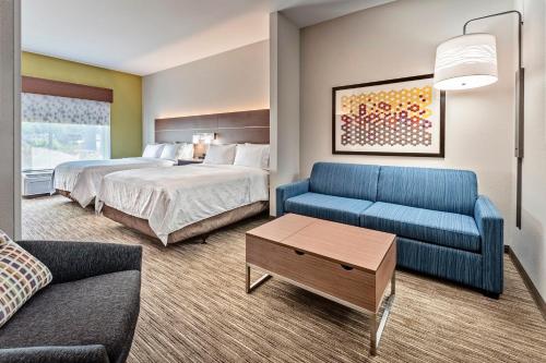 a hotel room with a bed and a couch at Holiday Inn Express Hotel & Suites Lake Zurich-Barrington by IHG in Lake Zurich