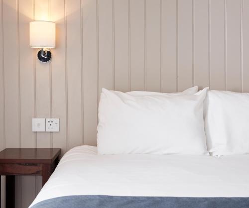 a bedroom with a bed with white sheets and a lamp at Darrington by Greene King Inns in Darrington