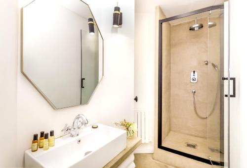 une salle de bain avec un lavabo et une douche dans l'établissement Habitat Parisien - 1BR-1BA - Louvre, à Paris