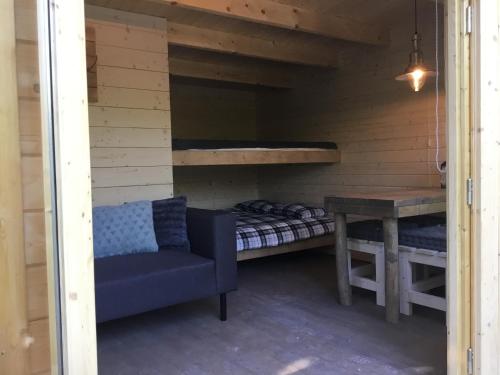 a room with a bed and a bench and a table at Cozy Lodge near Brattforsheden nature reserve in Filipstad