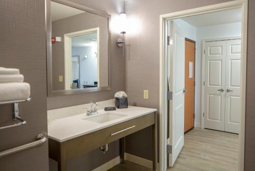 a bathroom with a sink and a mirror at Holiday Inn Hotel & Suites Bloomington Airport, an IHG Hotel in Bloomington