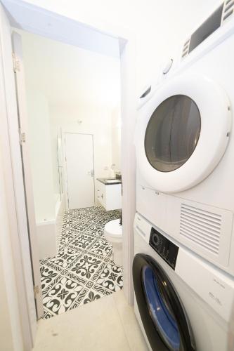 a washer and dryer in a bathroom with a toilet at Presiada heart of Akko in ‘Akko