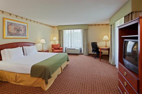 a hotel room with a bed and a flat screen tv at Holiday Inn Express Hotel & Suites-North East by IHG in North East