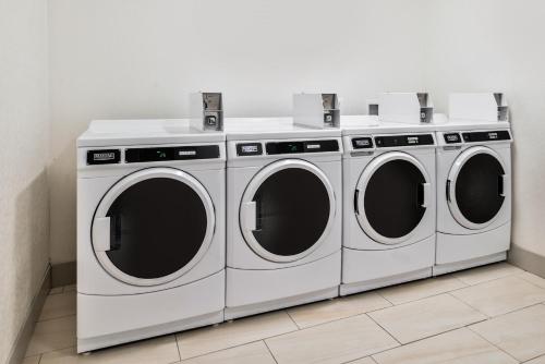 three white washing machines in a laundry room at Holiday Inn Express & Suites - Siloam Springs by IHG in Siloam Springs