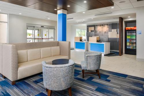 eine Lobby mit einem Sofa und 2 Stühlen in der Unterkunft Holiday Inn Express & Suites - Siloam Springs, an IHG Hotel in Siloam Springs