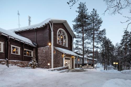 a building in the snow with snow on the ground at Lapland Hotels Bear´s Lodge in Sinettä