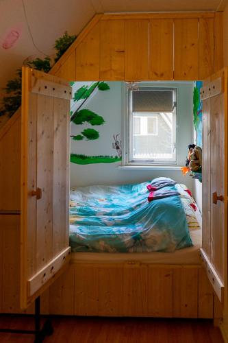 a bedroom with a bunk bed with a window at Nieuw: Kom in de Bedstee Uniek! in Winterswijk