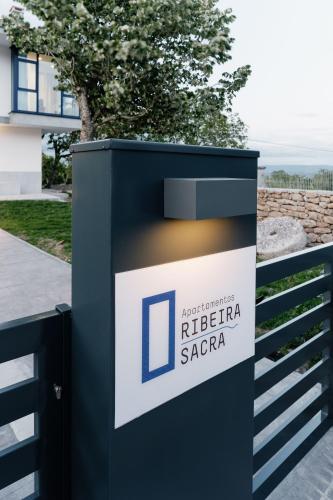 a sign for a ribera saapa in front of a fence at Apartamentos Ribeira Sacra in Parada del Sil